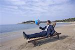 Businessman on chaise lounge with globe