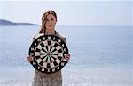 Businesswoman on beach with dartboard