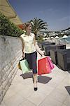 Frau zu Fuß auf der Promenade mit Einkaufstaschen