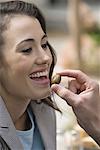 Man's hand feeding woman an olive