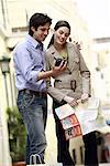 Couple with map looking at digital camera