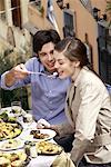 Man feeding woman at restaurant