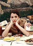 Woman sulking at restaurant table with Euro bills