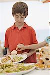 Boy being served by girl at buffet