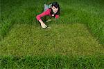 Woman Cutting Grass With Scissors