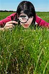 Woman Examining Grass With Magnifying Glass