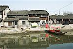 Chine, Guangdong Province, maisons sur le bord de l'eau, avec le bateau