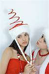 Two young female friends dressed in Christmas costumes, looking sad, portrait