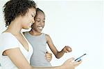 Mother and daughter looking at cell phone together, smiling