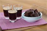 Three glasses of coffee next to a bowl with cookies