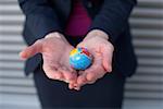Businesswoman holding a mini globe on hands