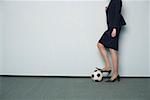 Die geschäftsfrau Fuß auf einen Fußball