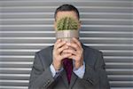 Businessman covering face with a cactus