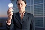 Businesswoman holding an electric bulb