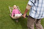 Father Pushing Daughter in Wheelbarrow