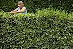 Woman Trimming Hedge