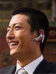 Businessman with headset smiling outdoors