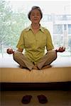 Mature woman sitting cross legged in meditation