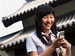 Adolescente en uniforme scolaire, sourire avec lecteur mp3