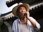 Mature man talking on cell phone outdoors smiling