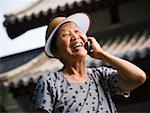 Woman with sun visor outdoors smiling talking on cell phone