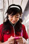 Teenage girl listening to mp3 player smiling