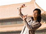 Businesswoman doing tai chi outdoors smiling