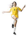 Teenage girl kicking soccer ball