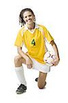 Teenage girl holding soccer ball smiling