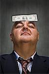 Businessman with Dollar Bill on Head