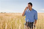 Man Using Cellphone in Field