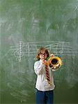 Boy Playing Trombone in Classroom