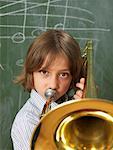 Boy Playing Trombone in Classroom