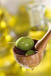 green olives in wooden spoon