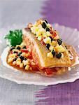 Piece of salmon cooked on one side with crushed vegetables, apples and capers