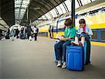 Children Waiting with Luggage at Train Station