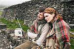 Couple assis par Stone Wall, Irlande