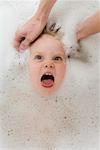 Hands Washing Girl's Hair in Bathtub