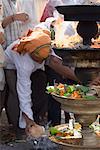 Homme faire une offrande religieuse de noix de coco, Tirupati, Temple de Venkateswara Tirumala, Tirumala, Andhra Pradesh, Inde