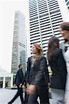 Flachwinkelansicht von Führungskräften zu Fuß auf der Straße mit Wolkenkratzern im Hintergrund, Singapur