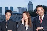 Geschäftsfrau mit zwei Geschäftsleute stehen und reden auf einem Mobiltelefon, Singapur