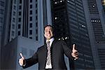 Portrait of a businessman making thumbs up signs and smiling, Singapore