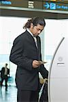 Businessman using express check- in service at an airport