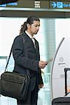 Businessman using express check- in service at an airport