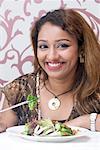 Porträt einer jungen Frau essen Salat mit Stäbchen und Lächeln