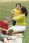 Mid adult man reading a book and a mid adult woman hugging her son