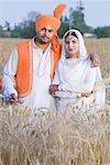 Portrait d'un statut de jeune couple dans un champ de blé