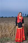 Portrait d'une jeune femme debout dans un champ de blé