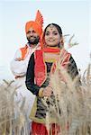 Jeune couple debout dans un champ de blé