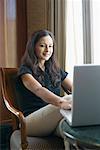 Businesswoman sitting on a chair and using a laptop